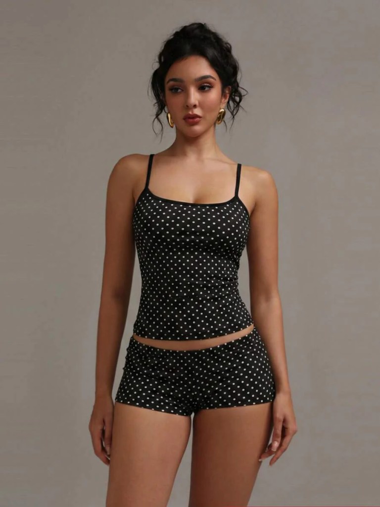 Model wearing a black polka dot tank top and matching shorts, standing against a neutral background.